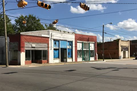 Small brick storefronts at an intersection in Lewiston Woodville