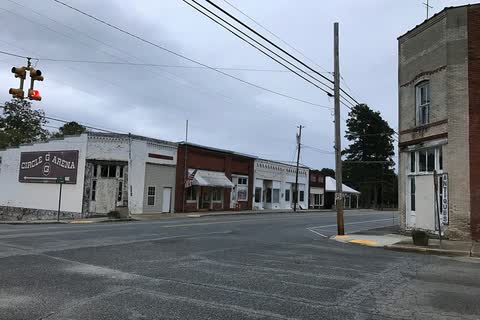 Street in Lilesville with old storefronts and a tall brick building on the right
