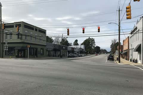 A downtown intersection with brick buildings and traffic signals in Lillington