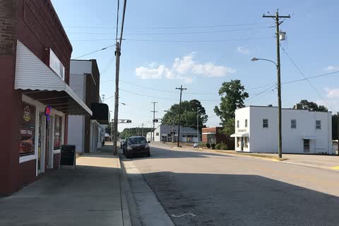 A sidewalk and storefronts along a quiet street in Lucama