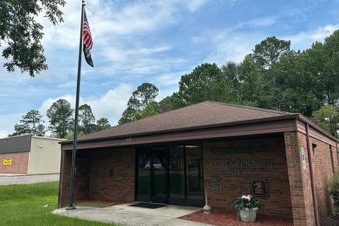 A small brick post office with a flagpole in Magnolia