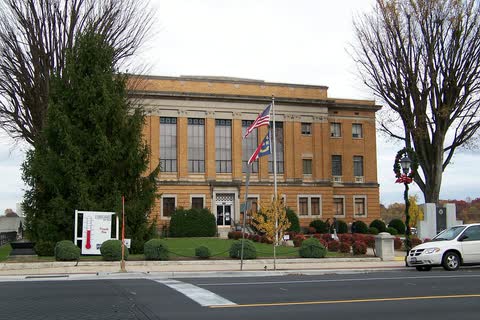 Brick McDowell County Courthouse with flags out front in Marion