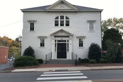 White two-story McAden Memorial Hall with a crosswalk in front