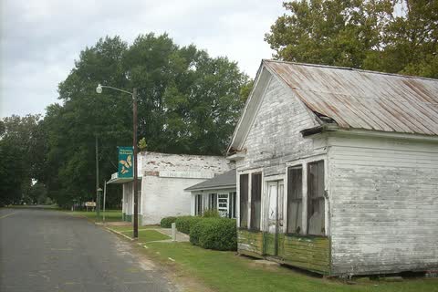 Quiet street in McDonald lined with old white wooden buildings and trees