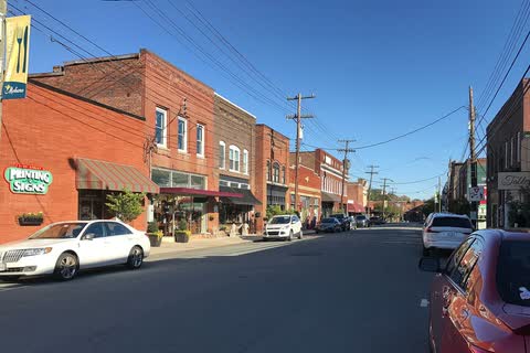 Downtown Mebane street with two-story brick storefronts and parked cars