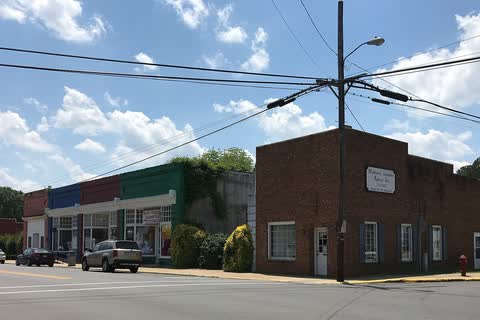 Brick storefronts at a corner in Middlesex under a partly cloudy sky