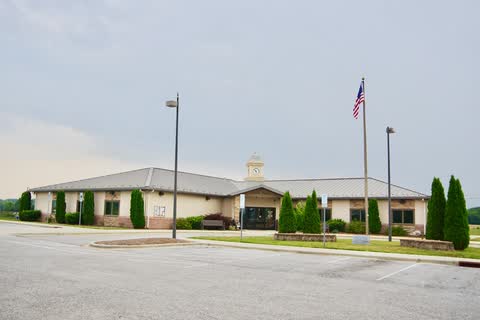 Low town hall and library building with a flagpole in Mills River