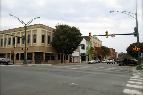 Corner of Main Street in Monroe with two-story historic commercial buildings and traffic lights