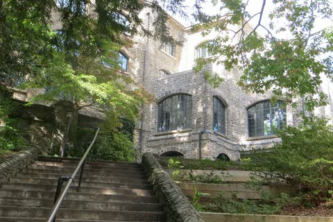 Stone Assembly Inn building with stone steps among trees in Montreat