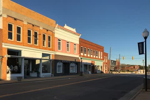 Row of restored brick storefronts on Main Street in Norwood in evening light