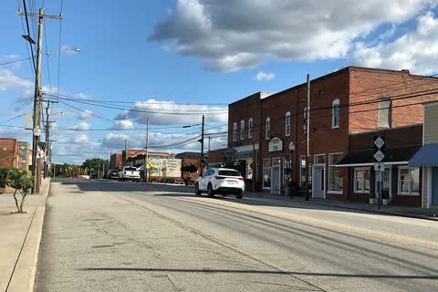 Brick storefronts along North Main Street in Oakboro under a cloudy blue sky