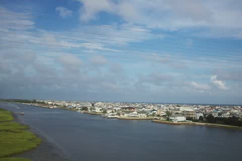 A low barrier island lined with houses across the water at Ocean Isle Beach