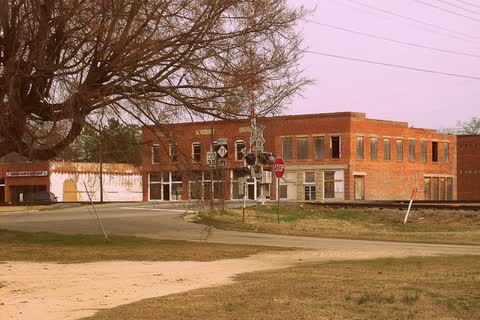 Old brick commercial buildings beyond a railroad crossing in Parkton