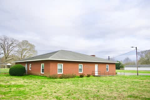Single-story brick Patterson Springs town hall with a lawn