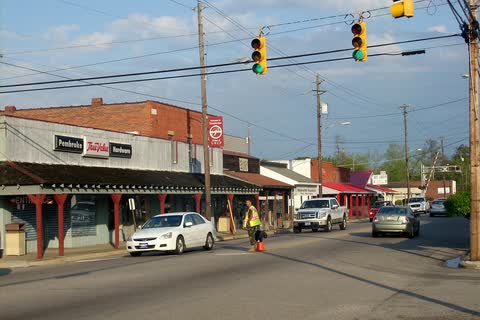 Street in Pembroke with covered storefronts, traffic lights and cars
