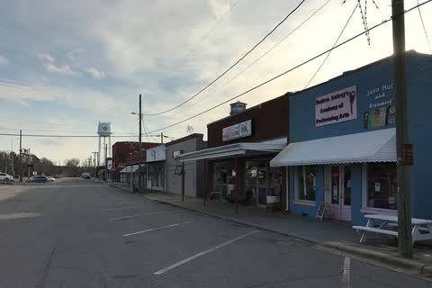 Storefronts along a street in Pikeville with the town water tower behind