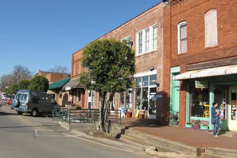 Brick shopfronts with a raised sidewalk along Hillsboro Street in Pittsboro