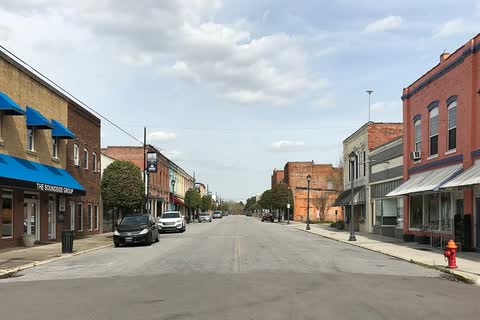 Brick storefronts with blue awnings along a downtown street in Plymouth