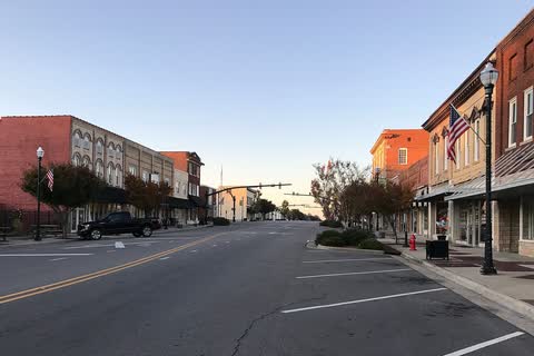 Wide street with historic brick storefronts and street lamps in Raeford