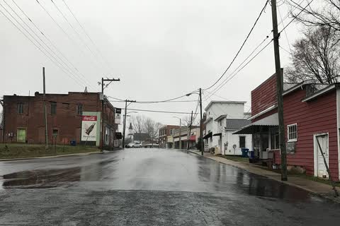 Rain-wet Main Street in Ramseur with old commercial buildings