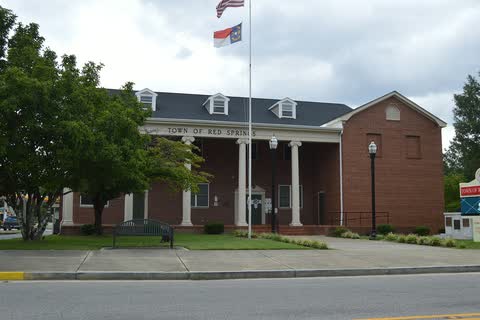 Red Springs Town Hall, a brick building with a white columned portico and a flagpole
