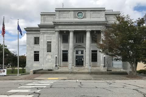 Columned stone municipal building with flags in Reidsville