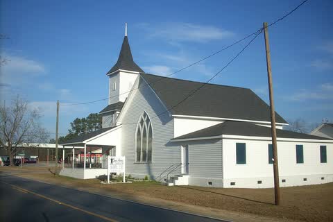 Open Arms Assembly of God church in Rennert, white with a steeple, beside a country road