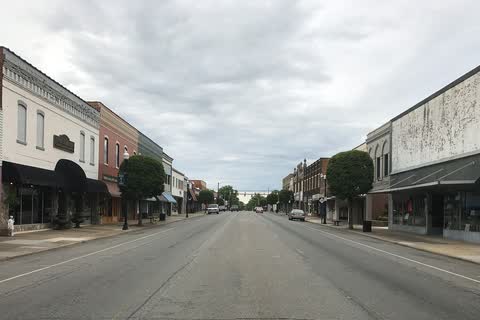 A wide downtown street lined with two-story storefronts in Roanoke Rapids