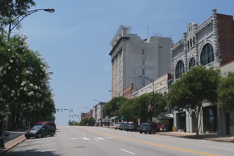 A wide downtown Salisbury street lined with historic brick and stone buildings and a tall office tower