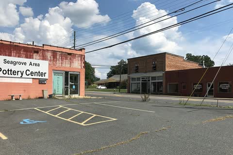 Seagrove Area Pottery Center building and brick storefronts under a blue sky