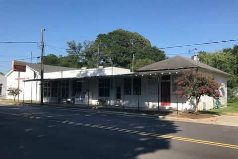 Low white commercial buildings along a street in Seven Springs