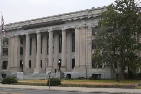 A wide neoclassical stone courthouse with a row of columns in Smithfield