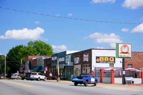 Row of small shops along Main Street in Spindale under a blue sky