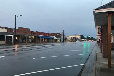 Rain-wet Main Street in St. Pauls lined with low storefronts
