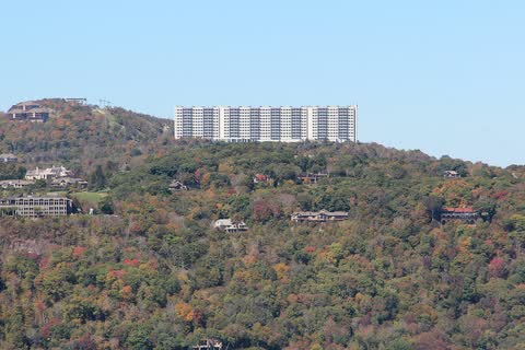Wooded slopes of Sugar Mountain in fall color with the Sugar Top building on the summit