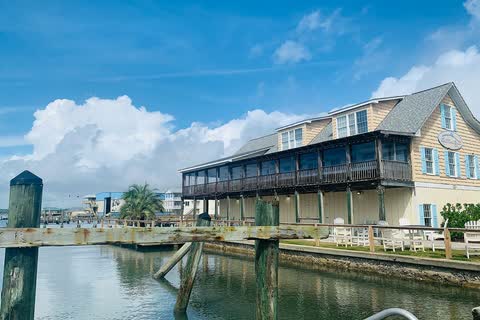 A two-story waterfront building with porches beside docks in Swansboro