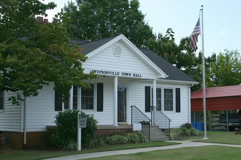 Swepsonville Town Hall, a small white building with a flagpole and front steps