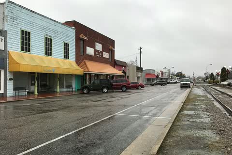 Storefronts with awnings along a downtown street beside the railroad in Tabor City