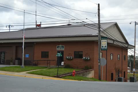 Brick Taylorsville town hall with a metal roof at a street corner