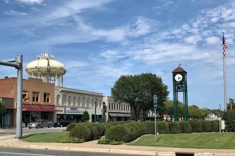 Downtown Thomasville storefronts with a clock post and a water tower behind them
