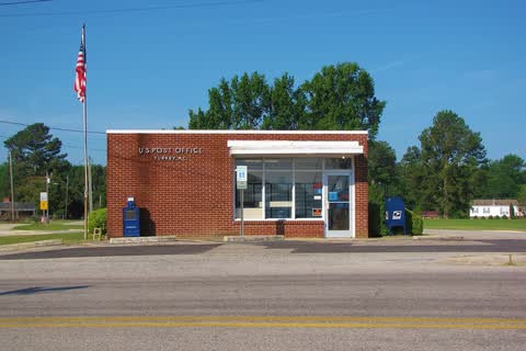 A small brick post office with a flagpole in Turkey
