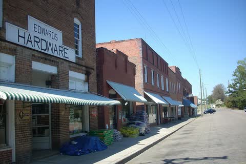 Old brick storefronts with awnings along Seaboard Street in Vass
