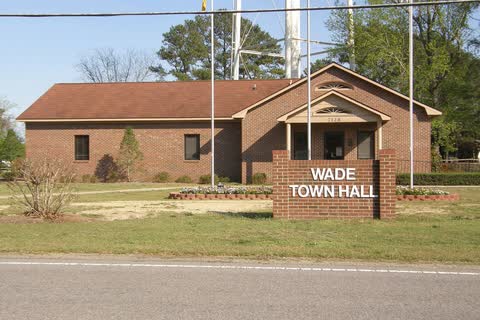 A one-story brick town hall with a 'Wade Town Hall' sign in Wade