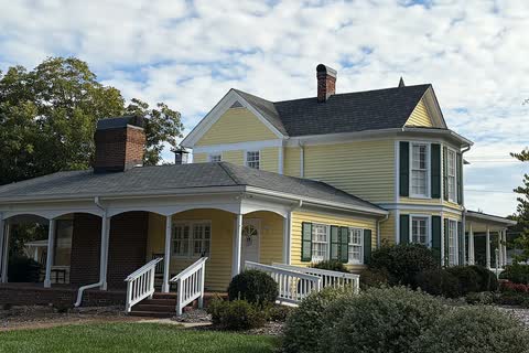 Yellow Victorian house with a wraparound porch that serves as Weddington Town Hall