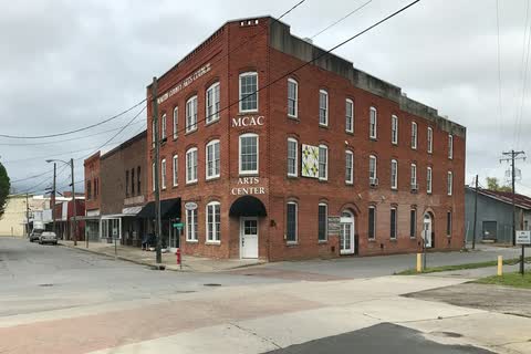 A three-story red-brick building at a downtown corner in Williamston