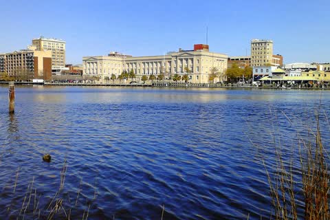 Downtown Wilmington's riverfront buildings seen across the Cape Fear River