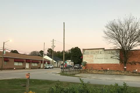 Low buildings along a street in Youngsville at dusk